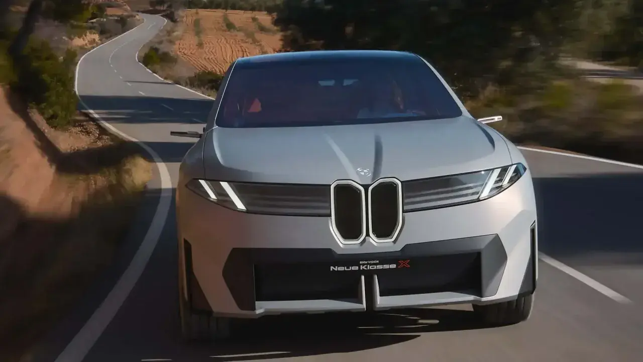 La BMW Neue Klasse X sfreccia su una strada tortuosa, un'icona di design futuristico.