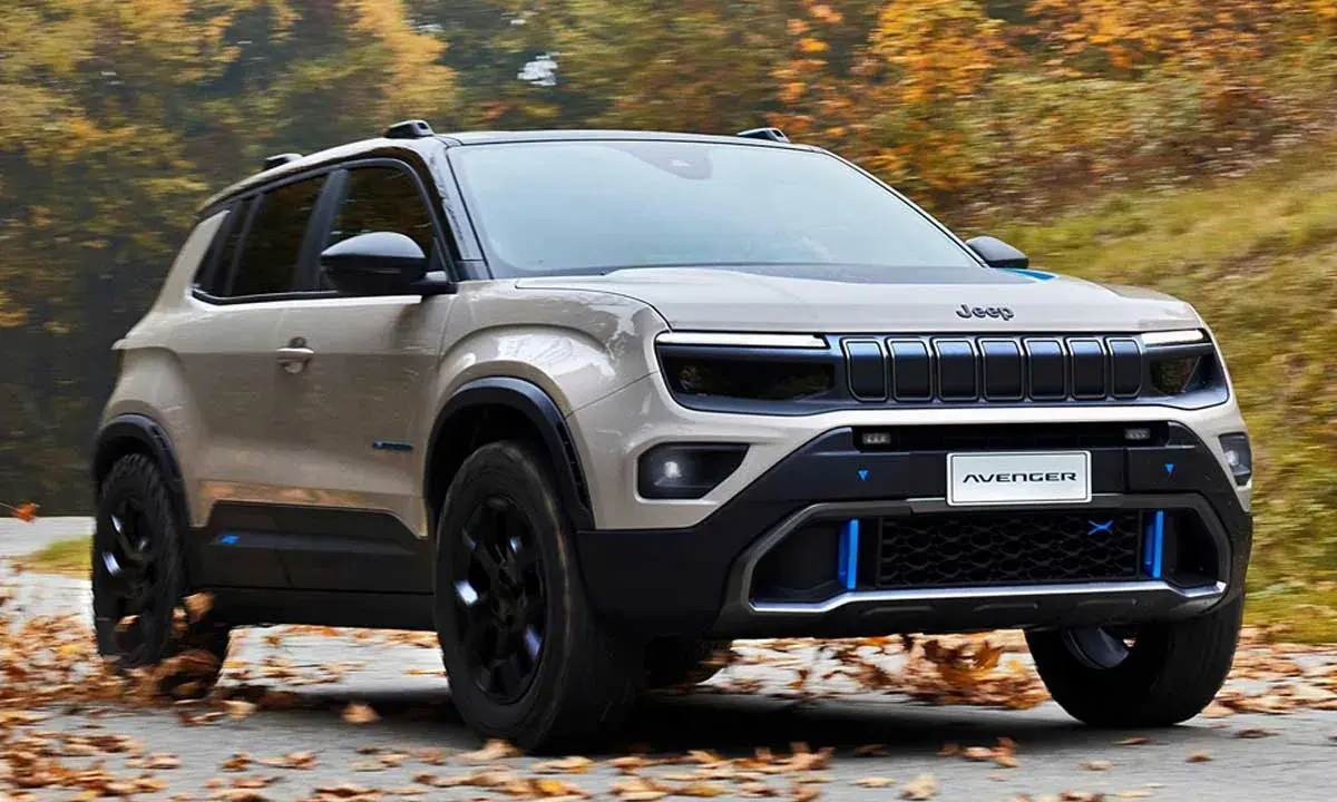 Jeep Avenger in beige, su strada autunnale. Nonostante le jeep avenger recensioni negative, il design è accattivante.