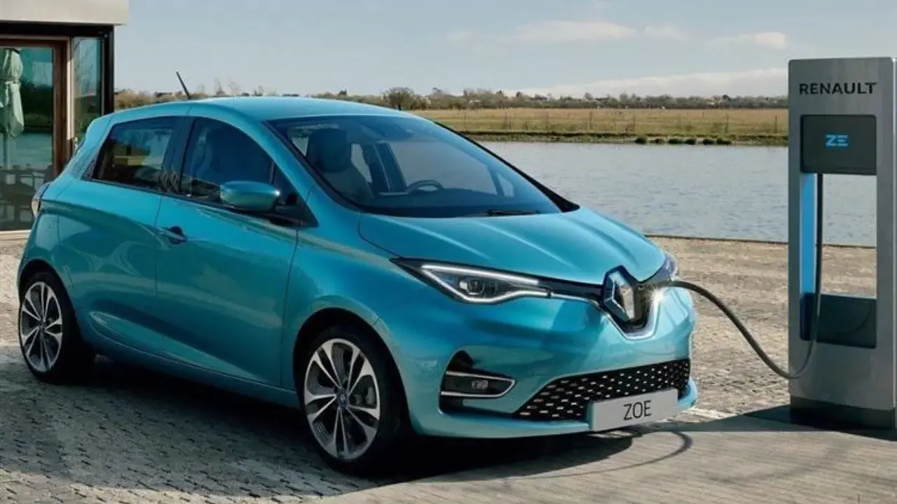 Renault Zoe, una delle auto elettriche più vendute, in carica vicino a un lago.