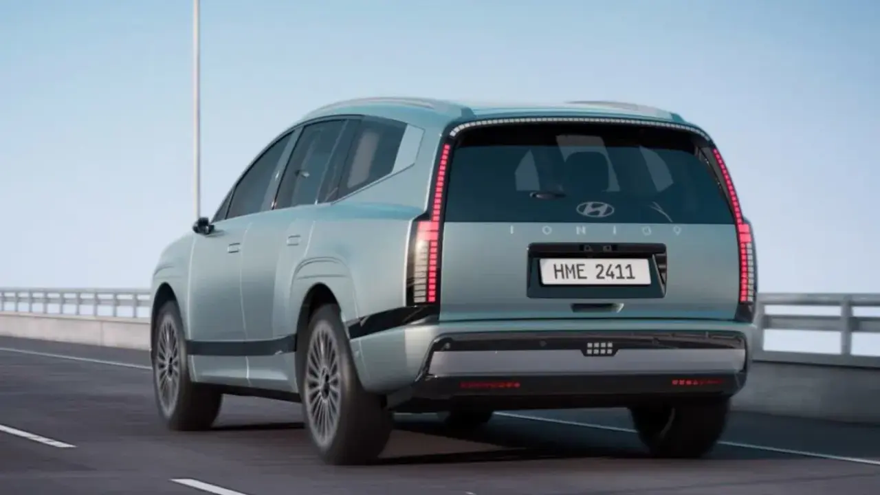 La nuova Ioniq 9, un SUV elettrico dal design futuristico, sfreccia su un'autostrada sotto un cielo azzurro.