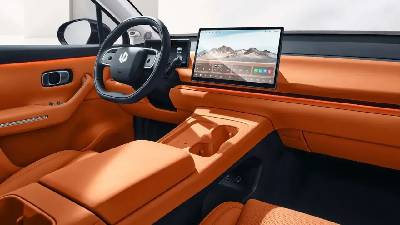 Interni eleganti e moderni della Leapmotor C10, con sedili in pelle arancione, ampio display centrale e volante sportivo.