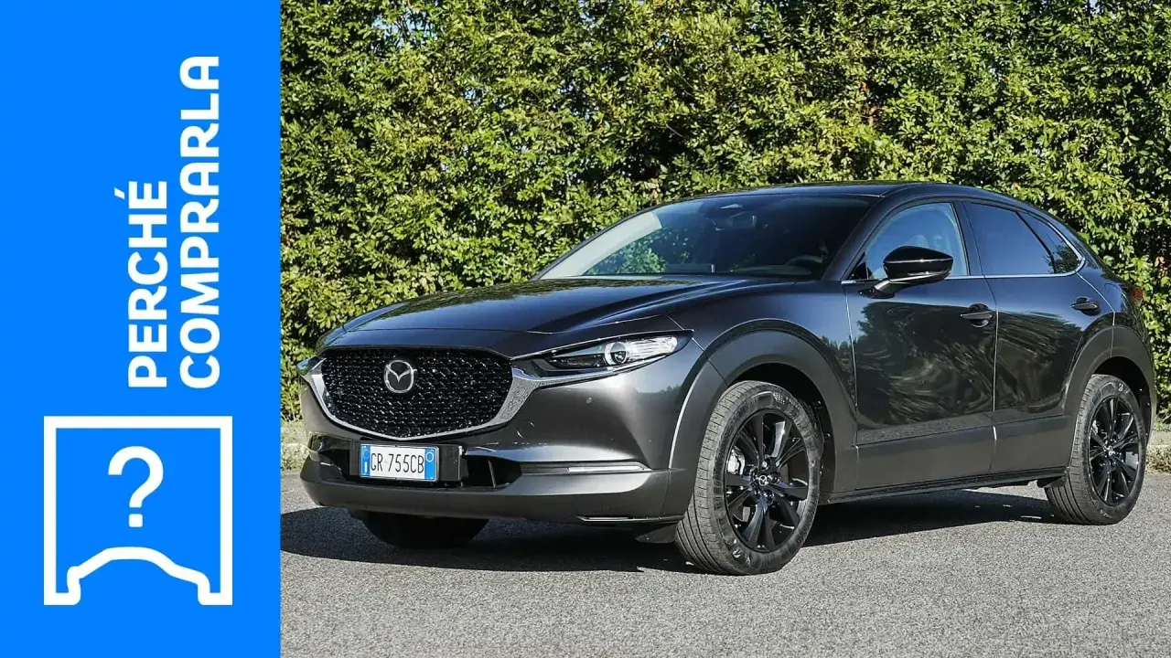 Mazda CX-30 grigia parcheggiata, con testo "Perché comprarla" e un punto interrogativo. Valutazione dei **problemi** della Mazda CX-30.