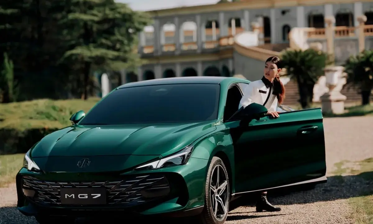 Elegante donna esce dalla MG 7 verde smeraldo, con un palazzo storico sullo sfondo.