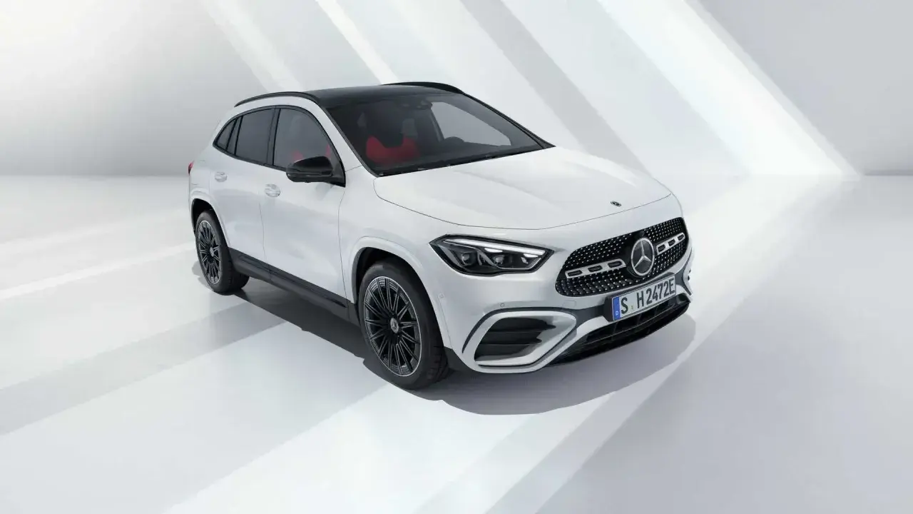 La nuova GLA 2026, un SUV bianco con tetto nero e interni rossi, si presenta in uno studio minimalista.