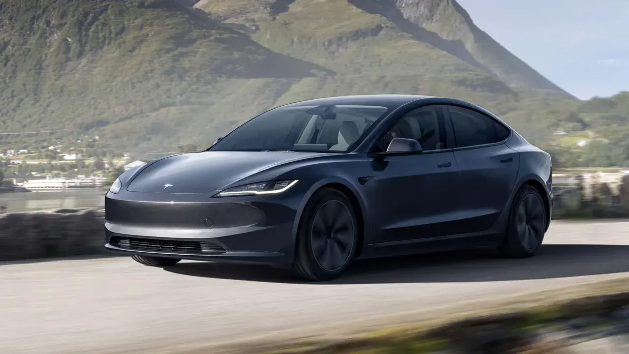 Tesla Model 3 grigia in movimento su strada panoramica, un'opzione tesla economica per esplorare la natura.