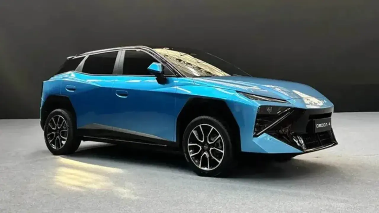 Un'elegante Omoda 4 blu metallizzato, con un design futuristico e cerchi in lega sportivi, si presenta su un pavimento grigio.