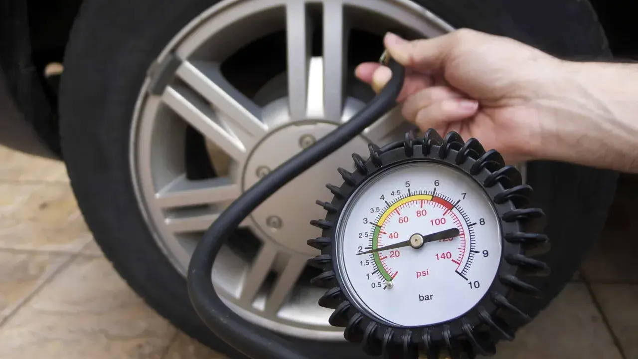 Controllo della pressione delle gomme auto con manometro. La lancetta indica circa 2 bar.
