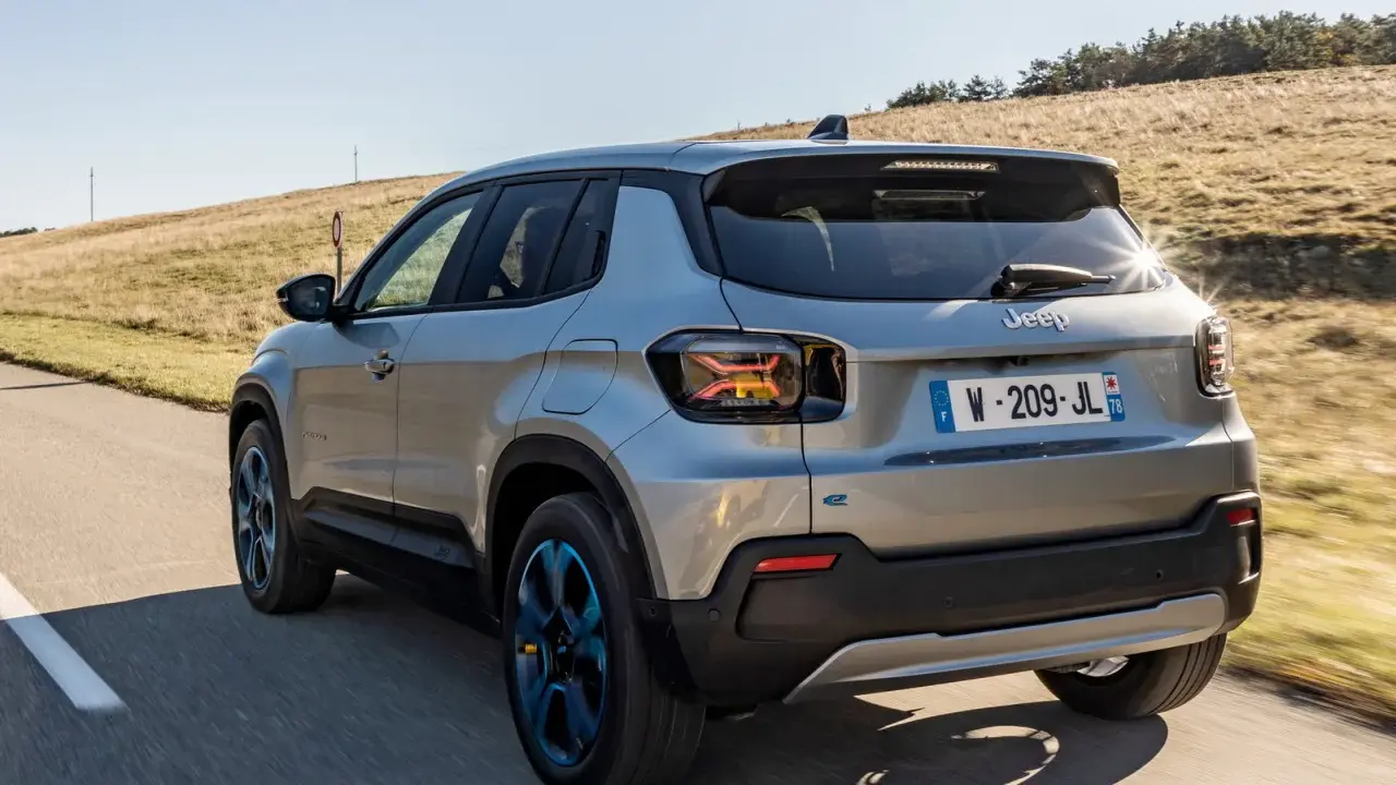 Jeep Avenger elettrica in corsa su strada panoramica, con cerchi blu e un'ottima autonomia per esplorare.