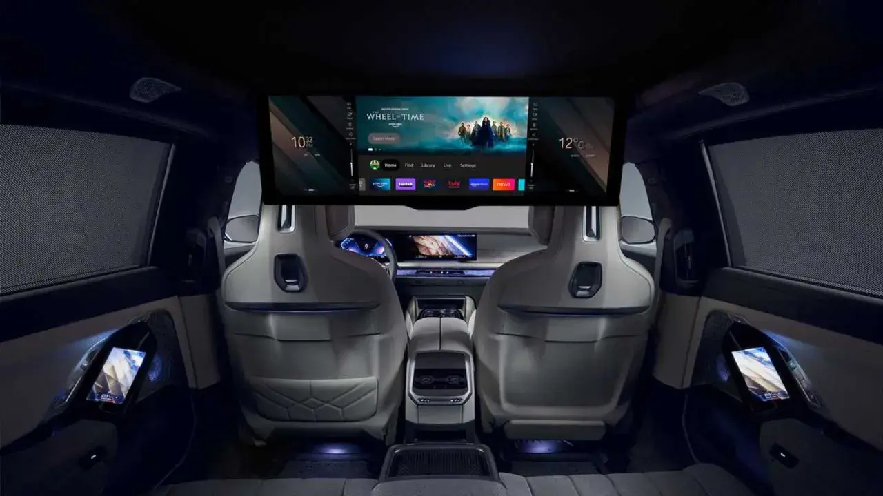 Interni lussuosi della BMW i7 con un grande schermo per l'intrattenimento e schermi sui pannelli delle porte.