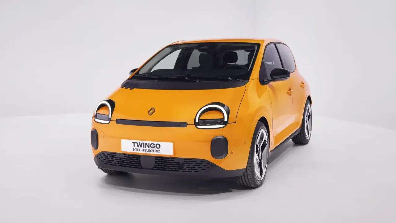 Renault elettrica piccola color arancio brillante, con fari rotondi e scritta "Twingo E-Tech Electric" sul frontale.