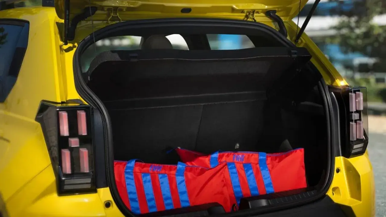 Bagagli rossi con strisce blu nel bagagliaio di una Fiat Panda, dimensioni generose per ogni avventura.