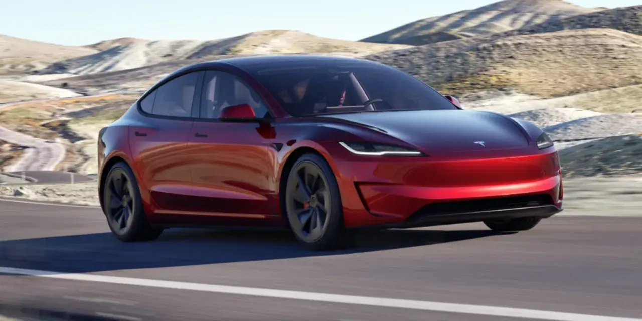 Tesla Model 3 rossa su strada panoramica. Il suo peso è ottimizzato per prestazioni elettriche.