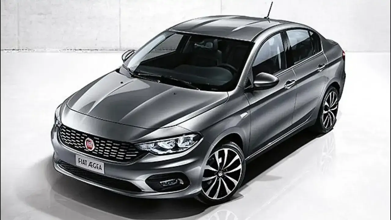 La Fiat Egea grigia, un'elegante berlina, si presenta in uno studio con un design moderno e cerchi sportivi.
