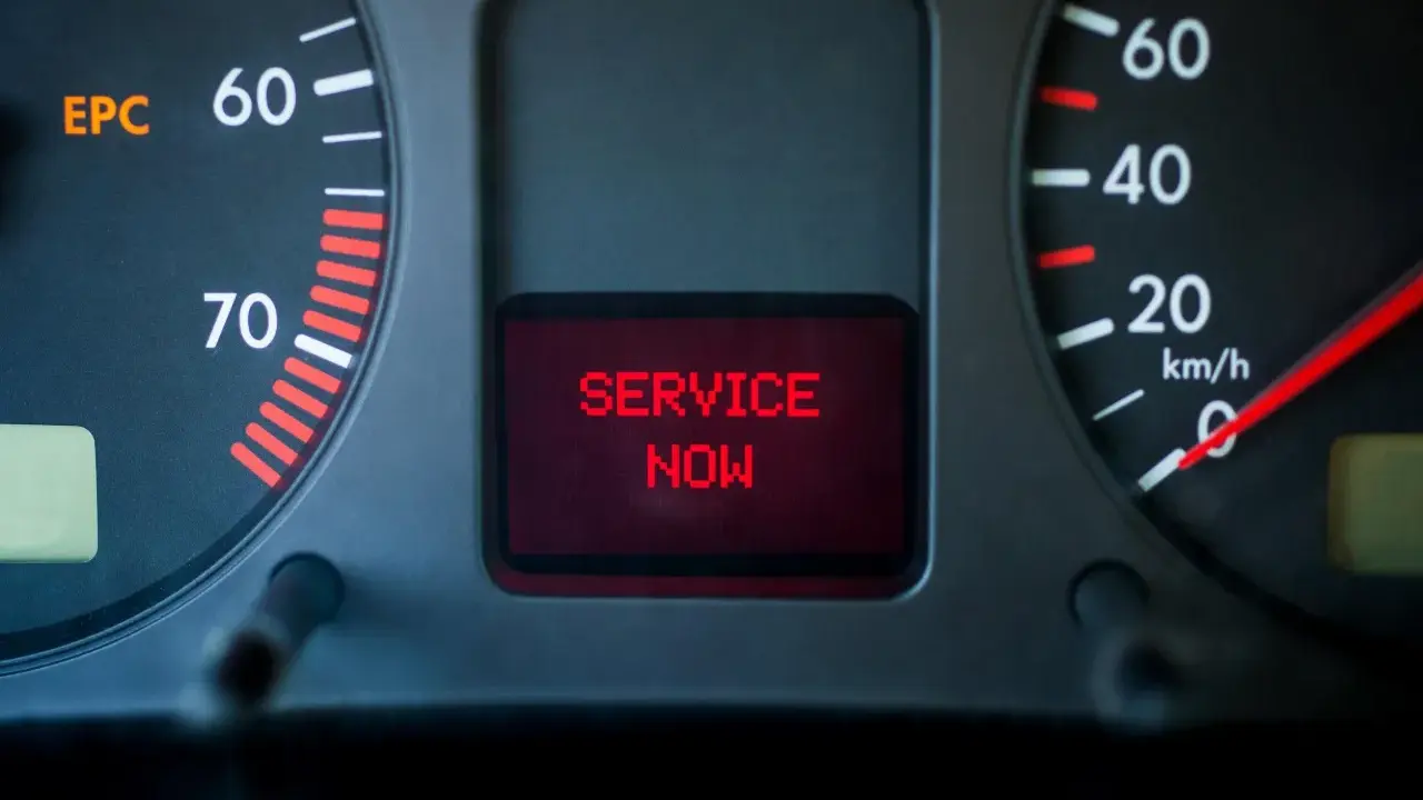 Car dashboard with EPC light on and "SERVICE NOW" message displayed in red.