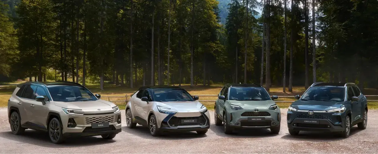 Quattro modelli Toyota, RAV4, C-HR, Yaris Cross e Corolla Cross, in un paesaggio boscoso.
