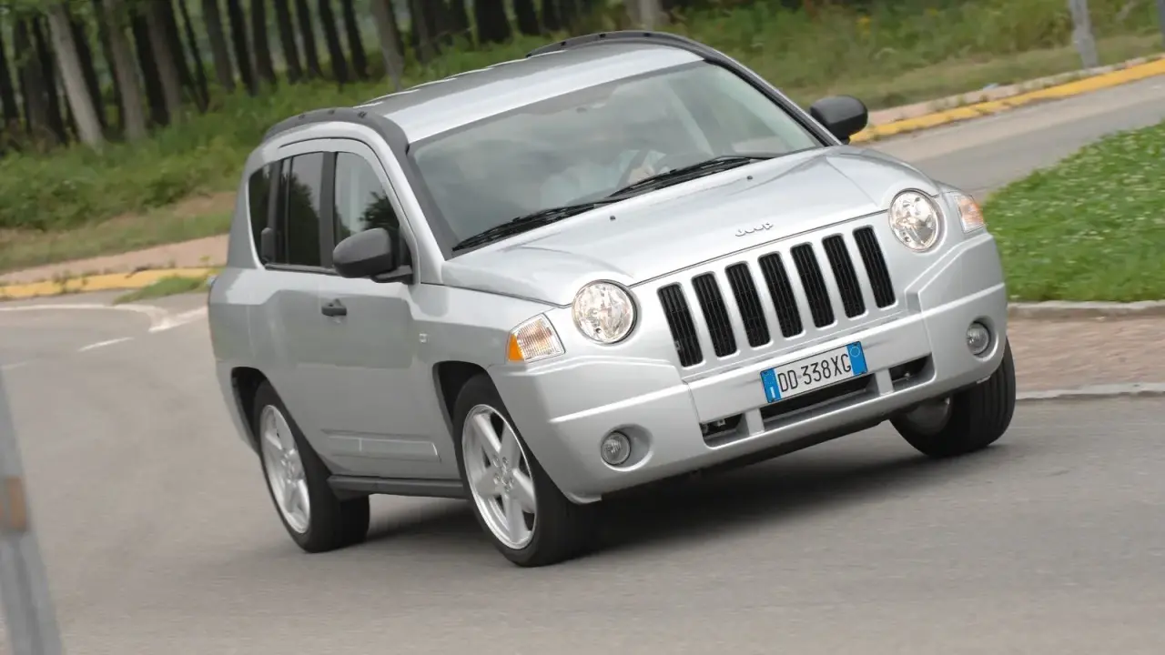 Jeep Compass in argento su strada sterrata, forse con qualche problema di trazione.