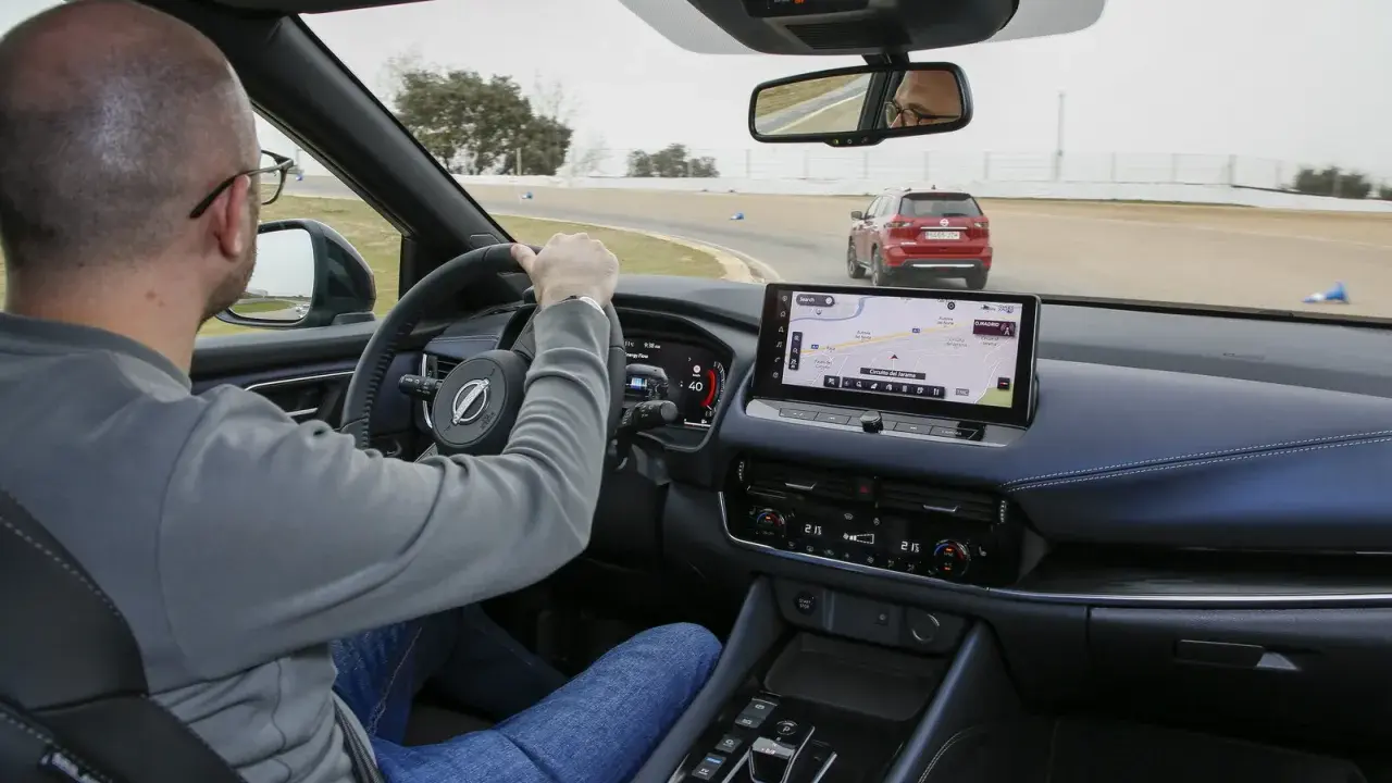 Uomo al volante su una pista, con un'altra auto rossa davanti. Il navigatore mostra il "Circuito del Jarama", ideale per chi vuole aumentare cavalli auto.