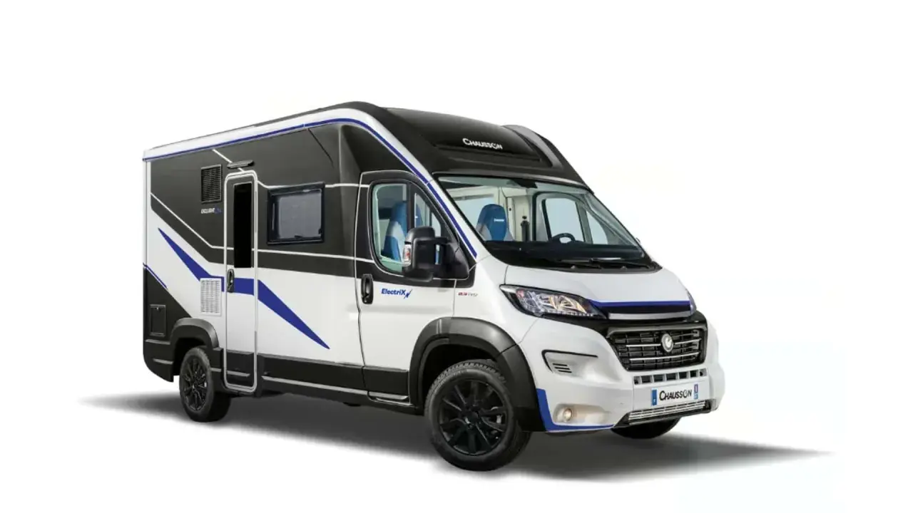 Camper elettrico bianco e nero con dettagli blu, pronto per avventure ecologiche.