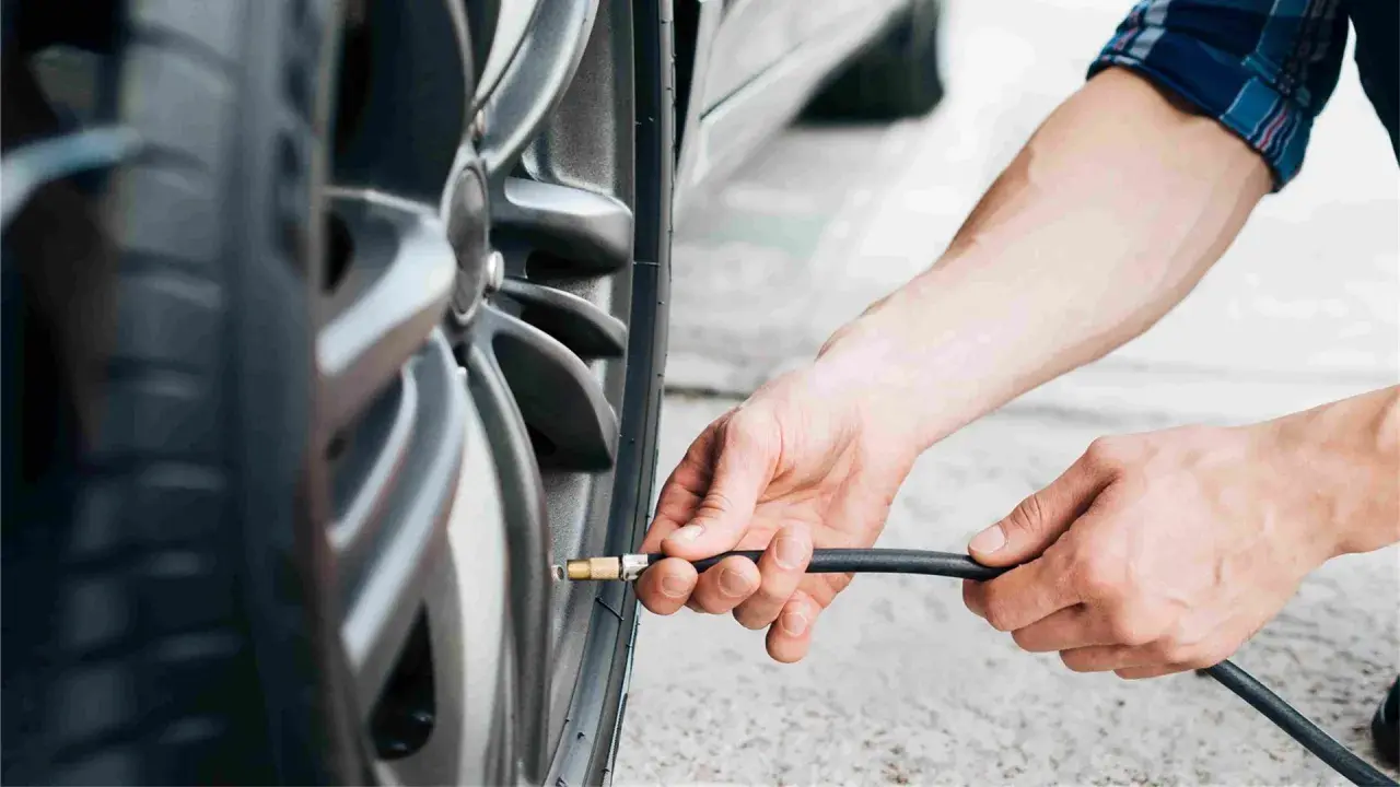 Mani che gonfiano uno pneumatico. Evitare pneumatici troppo gonfi conseguenze: usura irregolare e minore aderenza.