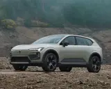 Volvo EX90, un SUV elettrico elegante, si avventura su un terreno roccioso e fangoso, pronto per l'esplorazione.