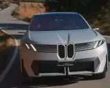 La BMW Neue Klasse X sfreccia su una strada tortuosa, un'icona di design futuristico.