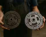 Un meccanico confronta un disco frizione usurato con uno nuovo. Potrebbe essere la causa se il motore diesel non sale di giri.