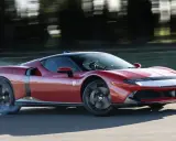 Ferrari 849 Testarossa sfreccia in pista, sollevando fumo dagli pneumatici. Un'icona di velocità e design.