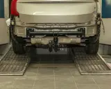 Installazione gancio traino auto: il costo varia in base al modello. L'auto è sollevata su rampe in officina.