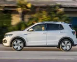 Bianca T-Cross sfreccia su strada, con la sua conducente che gode del viaggio. Un'auto compatta ma spaziosa, perfetta per ogni avventura.