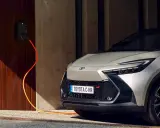 Toyota C-HR GR in argento, con cavo arancione collegato alla stazione di ricarica. L'auto plug-in è pronta per la sua prossima avventura.