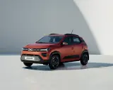 Dacia Spring, un'auto elettrica arancione, pronta per un viaggio in autostrada con la sua autonomia.
