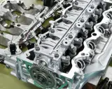 Parti di un motore rigenerato, con pistoni, valvole e ingranaggi in primo piano.