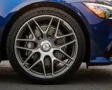 Ruota di un'auto blu con cerchi AMG e freni a disco forati. Il pneumatico Michelin mostra un leggero segno di usura.