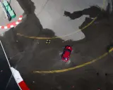 Auto rossa in derapata su asfalto bagnato, con coni arancioni e segnali di pista. I pneumatici Kumho mostrano i loro limiti in condizioni difficili.