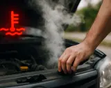 Spia candelette accesa, fumo dal motore e mano sul cofano. L'auto si surriscalda.
