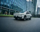 La Leapmotor C10 REEV sfreccia su strada, circondata da moderni grattacieli.