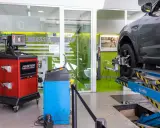 Attrezzatura per la convergenza auto in officina. Un'auto è sollevata su un ponte, con sensori applicati alla ruota.