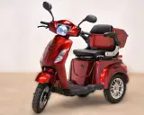 Un'auto elettrica a 3 ruote, rossa metallizzata, con sedile comodo e bauletto posteriore. Ideale per muoversi in città con stile e praticità.