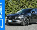 Mazda CX-30 grigia parcheggiata, con testo "Perché comprarla" e un punto interrogativo. Valutazione dei **problemi** della Mazda CX-30.