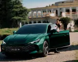 Elegante donna esce dalla MG 7 verde smeraldo, con un palazzo storico sullo sfondo.