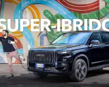Uomo con pistola benzina e cavo di ricarica accanto a un SUV nero, che simboleggia la tecnologia mild hybrid.
