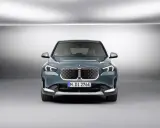 La BMW iX1, con la sua impressionante autonomia, si presenta frontalmente in un ambiente minimalista.