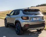 Jeep Avenger elettrica in corsa su strada panoramica, con cerchi blu e un'ottima autonomia per esplorare.