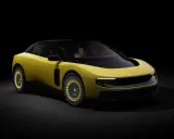 Un'audace Ferrari F244 gialla con tetto nero e cerchi dorati, illuminata da un fascio di luce su sfondo scuro.