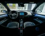Interni moderni della Toyota Aygo X: volante, cruscotto con navigatore e sedili in tessuto.