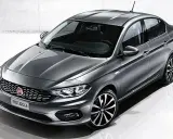 La Fiat Egea grigia, un'elegante berlina, si presenta in uno studio con un design moderno e cerchi sportivi.