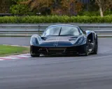 La Lotus Evija nera sfreccia su una pista, con un'aria di potenza e velocità.