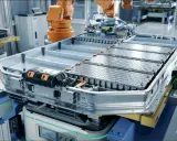 Assemblaggio di batterie del futuro in una fabbrica automatizzata. Un robot industriale lavora su un pacco batterie per veicoli elettrici.