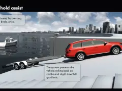 Auto rossa con rimorchio per barca su una rampa. Il sistema hill holder impedisce all'auto di arretrare in salita.