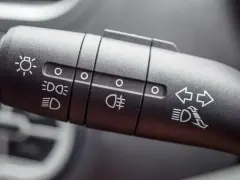 Comandi per luci di posizione spia e frecce su una leva dell'auto.